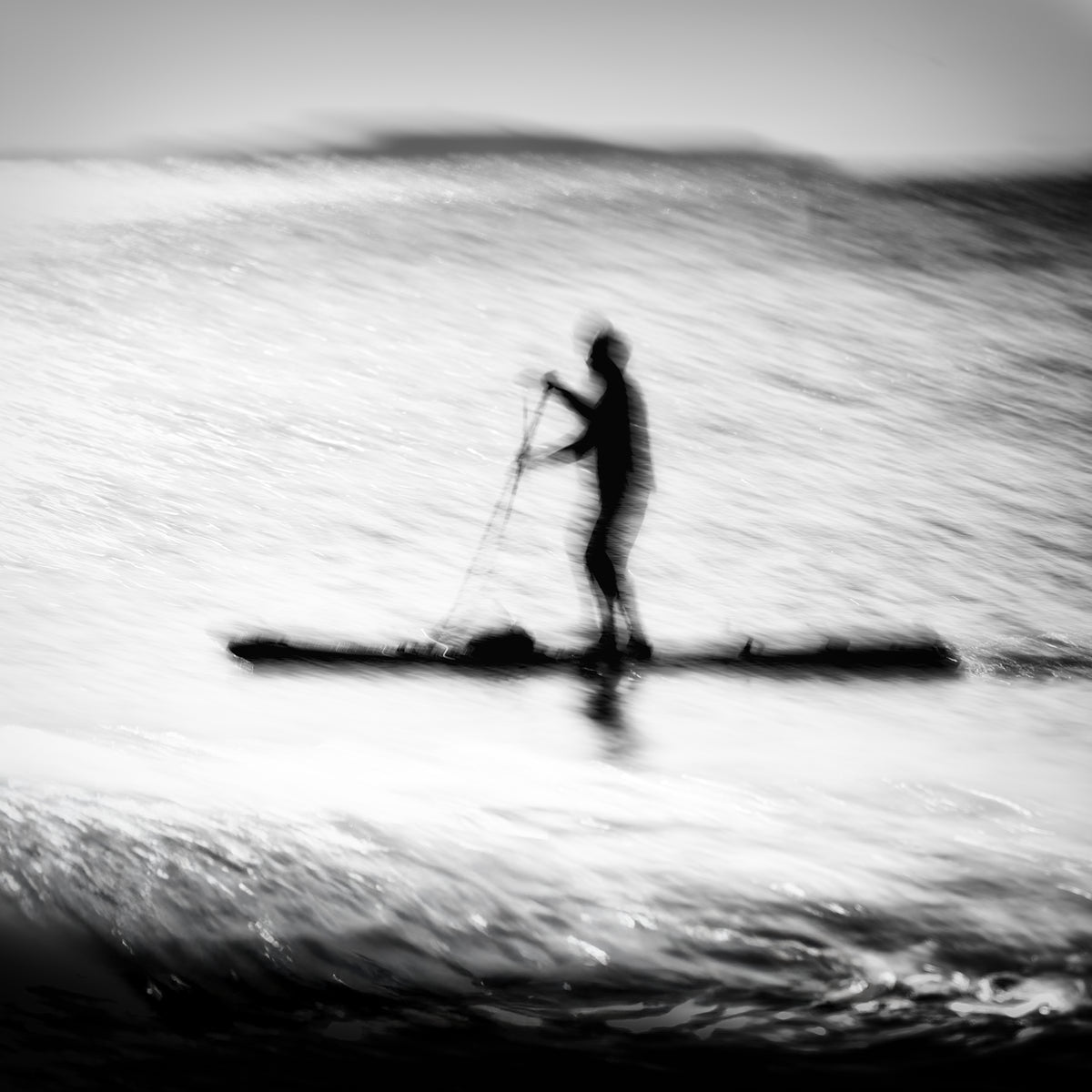 Hikari no Umi — lone paddleboarder silhouette on a glittering silver sea, black and white fine art photography